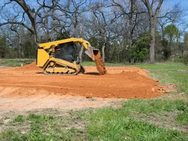 Excavator fine-grading a structural building pad with lifts and elevation control for a Baldwin County new build — Excavation Elite
