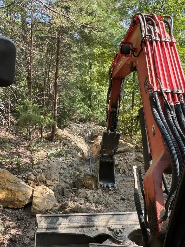 Excavator trenching for French drains, swales, and stormwater drainage on a Baldwin County homesite — Excavation Elite drainage solutions