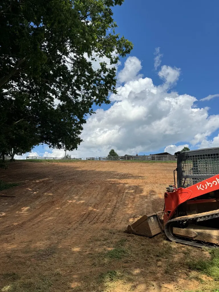 Heavy equipment performing site preparation grading, cut-fill, and drainage shaping on a Baldwin County construction lot — Excavation Elite