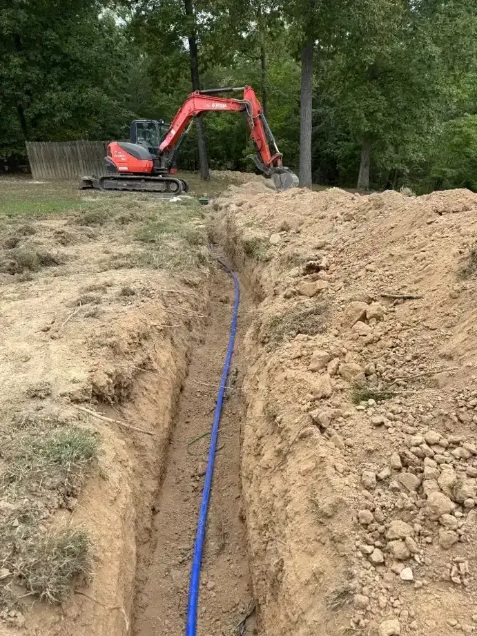 Utility trench excavation with bedding and lines staged for water, sewer, or conduit install on a Baldwin County jobsite — Excavation Elite